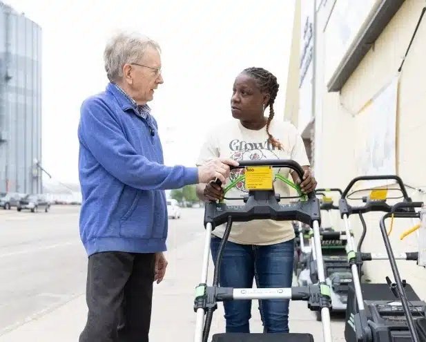 Two folks looking at power equipment at farm city supply