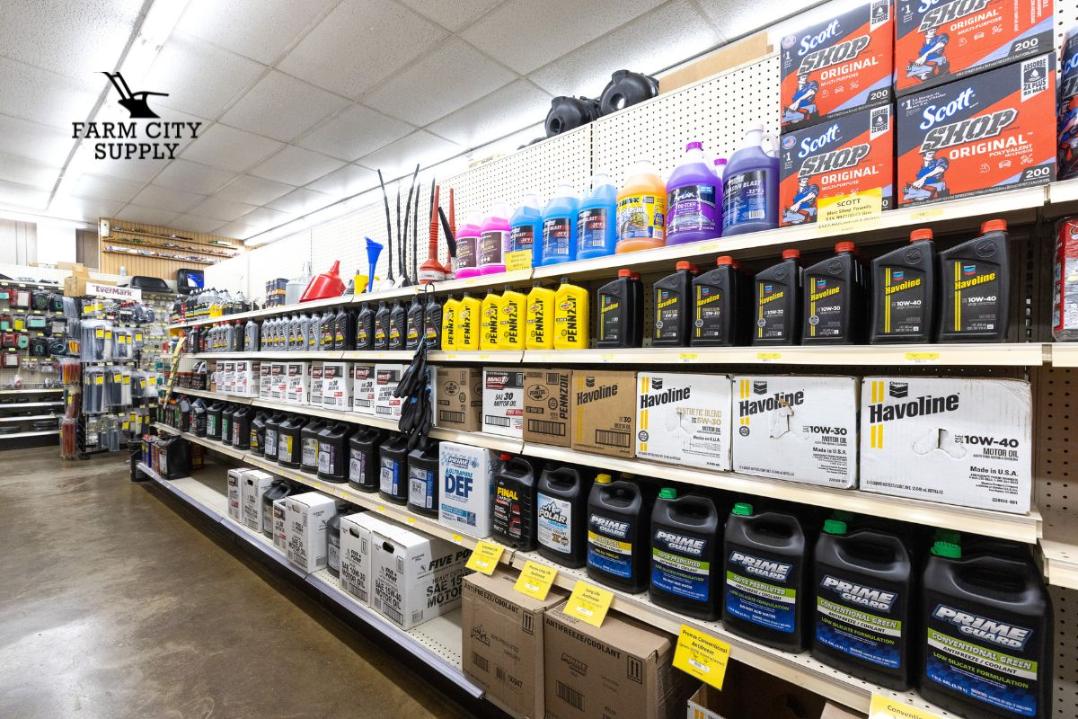 Essential automotive fluids, oils, and shop supplies displayed on shelves inside Farm City Supply.