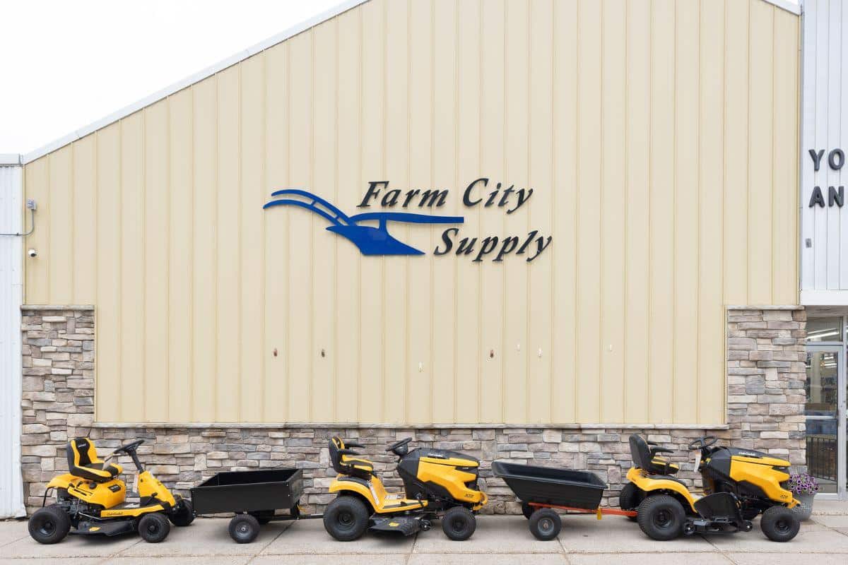 Outside view of Farm City Supply with riding lawn mowers lined up in front of the building.