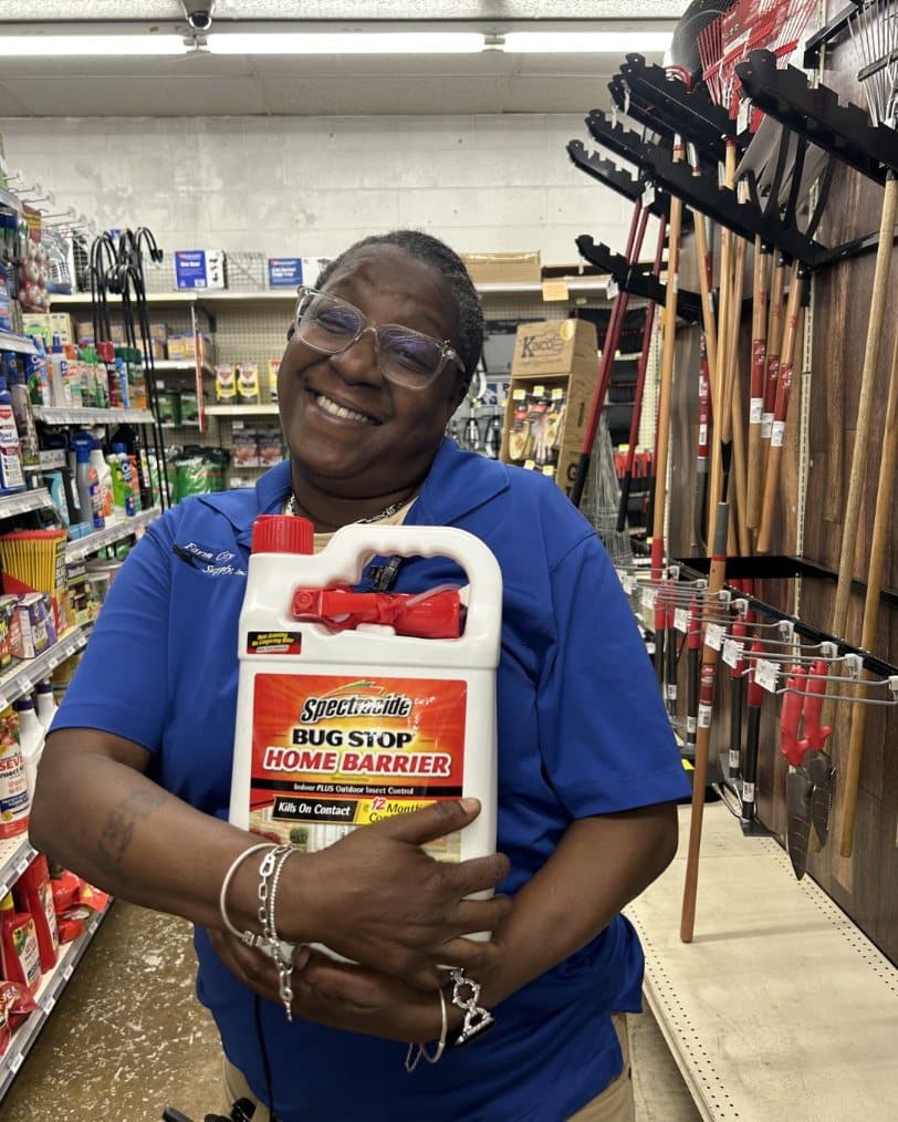 Farm City Supply employee holding a large container of Spectracide Bug Stop Home Barrier insect control.