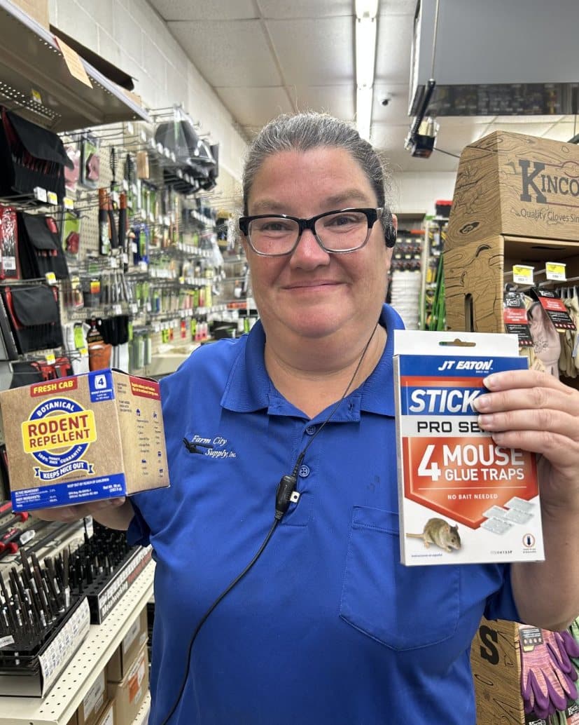 Farm City Supply employee holding Fresh Cab botanical rodent repellent and JT Eaton Stick-Em mouse glue traps.