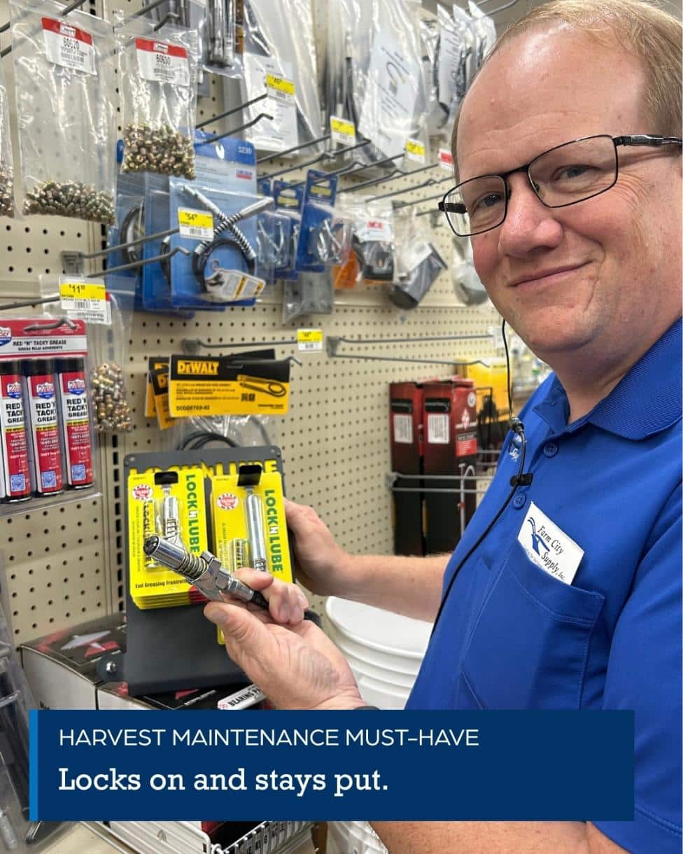Farm City Supply employee holding a bag of Spectracide Triazicide Insect Killer for Lawns in the pest-control aisle.